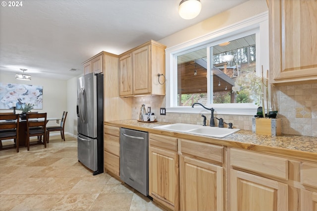 kitchen with tasteful backsplash, light brown cabinetry, sink, and appliances with stainless steel finishes