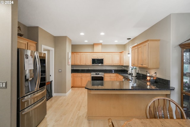 kitchen with sink, light hardwood / wood-style floors, pendant lighting, light brown cabinetry, and appliances with stainless steel finishes