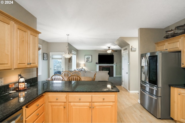 kitchen with kitchen peninsula, appliances with stainless steel finishes, ceiling fan, light hardwood / wood-style floors, and hanging light fixtures