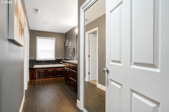 bathroom featuring wood-type flooring, vanity, and a tub