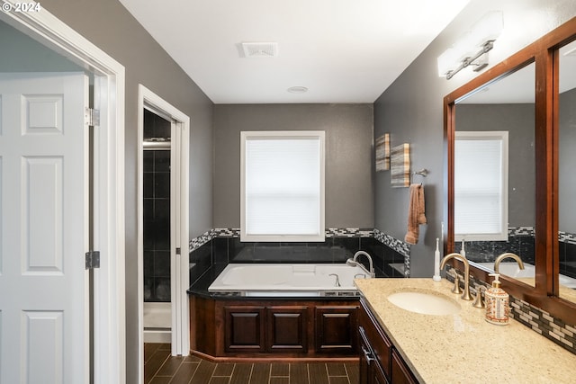 bathroom with shower with separate bathtub, vanity, and a healthy amount of sunlight