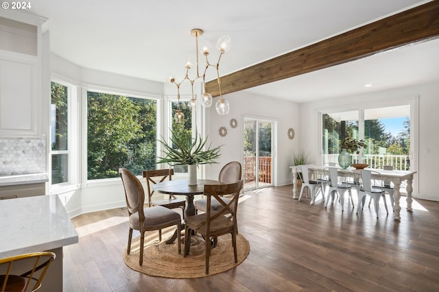 dining area with dark wood-type flooring, an inviting chandelier, a healthy amount of sunlight, and beam ceiling