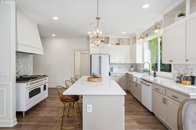 kitchen featuring a center island, dark wood-type flooring, white cabinetry, and high quality appliances