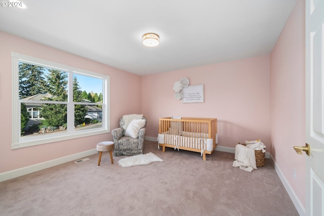 carpeted bedroom with a nursery area