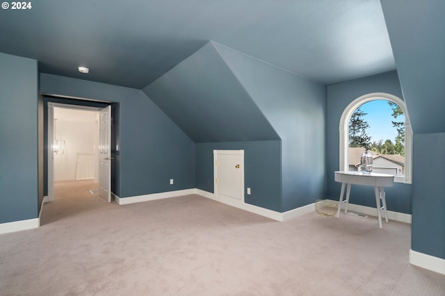 additional living space with lofted ceiling and light colored carpet