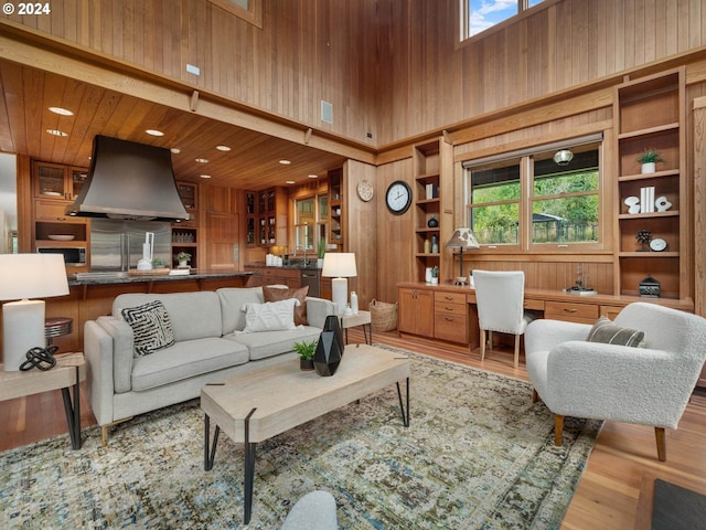 living room with hardwood / wood-style flooring, a healthy amount of sunlight, and wood walls