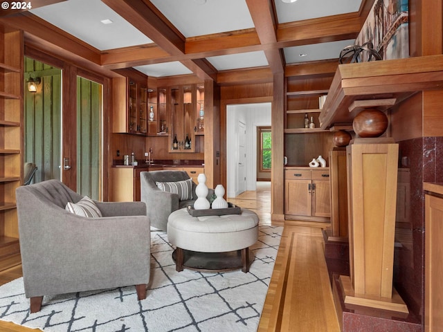 living room featuring wood walls, beamed ceiling, and coffered ceiling