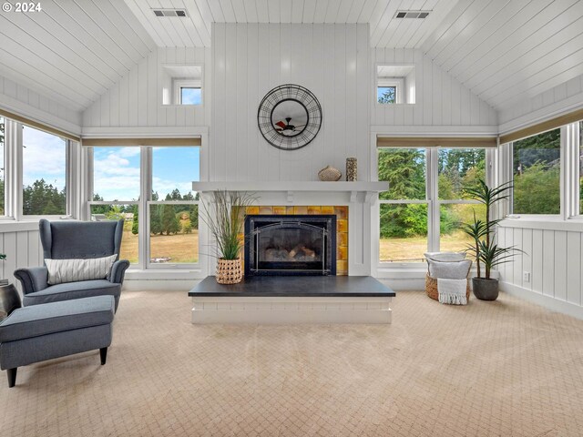 carpeted living room featuring a fireplace, high vaulted ceiling, and a healthy amount of sunlight