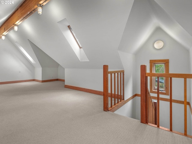 additional living space with carpet floors and lofted ceiling with skylight