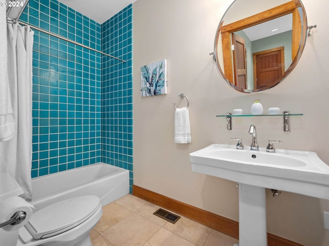 bathroom with shower / bath combo, tile patterned floors, and toilet