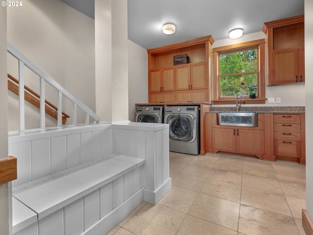 laundry room with light tile patterned floors, cabinets, sink, and washer and dryer