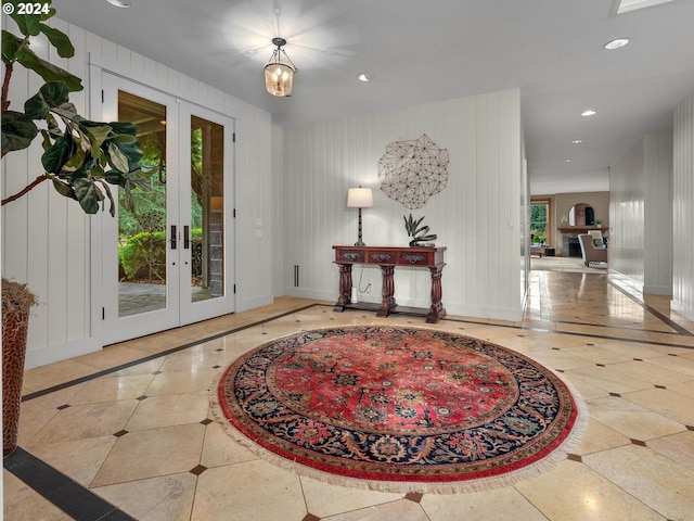 foyer with french doors and a notable chandelier