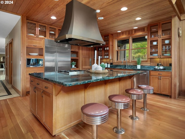 kitchen with a center island, wood ceiling, island range hood, light hardwood / wood-style flooring, and appliances with stainless steel finishes