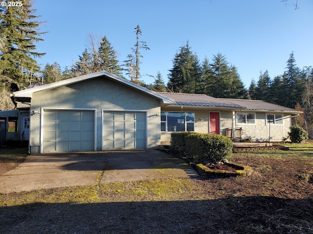 single story home featuring metal roof, a standing seam roof, an attached garage, and stucco siding