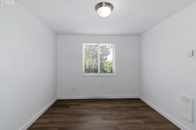 unfurnished room with dark wood-type flooring