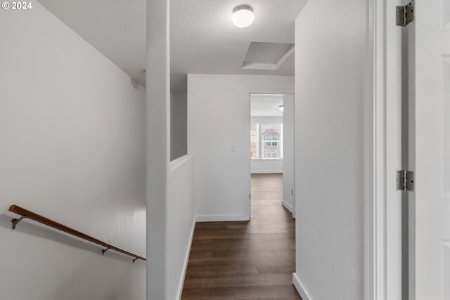 hall featuring dark hardwood / wood-style floors and a textured ceiling