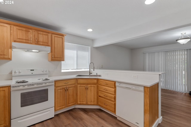 kitchen featuring white appliances, kitchen peninsula, sink, and hardwood / wood-style floors