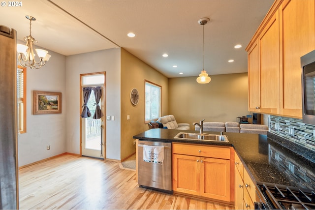 kitchen with pendant lighting, sink, kitchen peninsula, stainless steel appliances, and light wood-type flooring