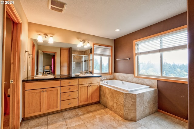 bathroom featuring a textured ceiling, tile patterned flooring, vanity, and shower with separate bathtub