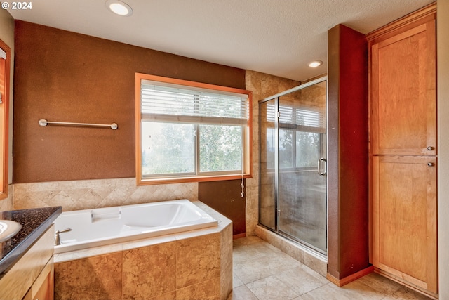 bathroom with independent shower and bath, vanity, tile patterned flooring, and a textured ceiling