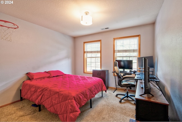 bedroom with carpet floors and a textured ceiling