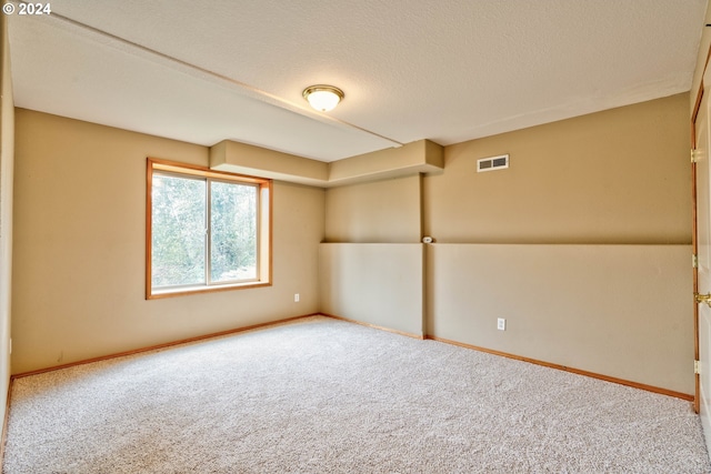 carpeted spare room featuring a textured ceiling