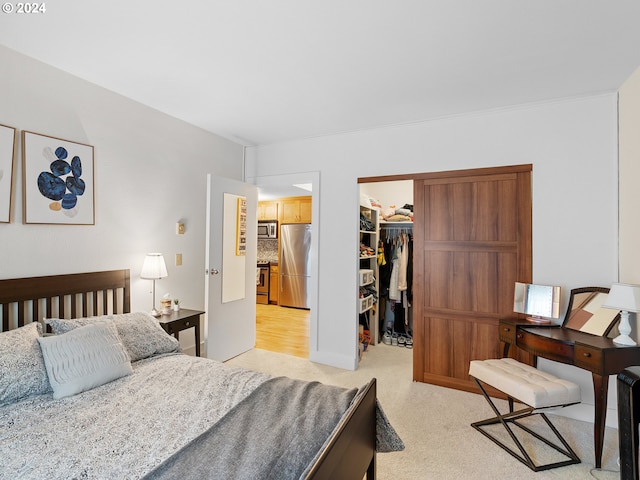 bedroom with a closet, a spacious closet, and stainless steel refrigerator