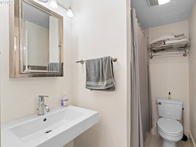 bathroom with sink, toilet, and a shower with curtain