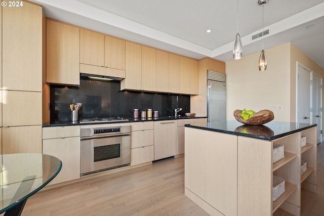 kitchen featuring appliances with stainless steel finishes, backsplash, light brown cabinetry, pendant lighting, and a center island