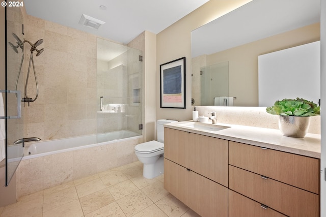 full bathroom with bath / shower combo with glass door, toilet, and vanity