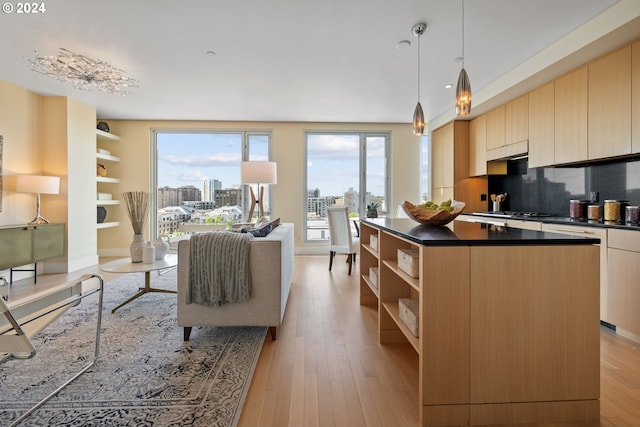 kitchen featuring backsplash, light brown cabinets, light hardwood / wood-style floors, and a kitchen island