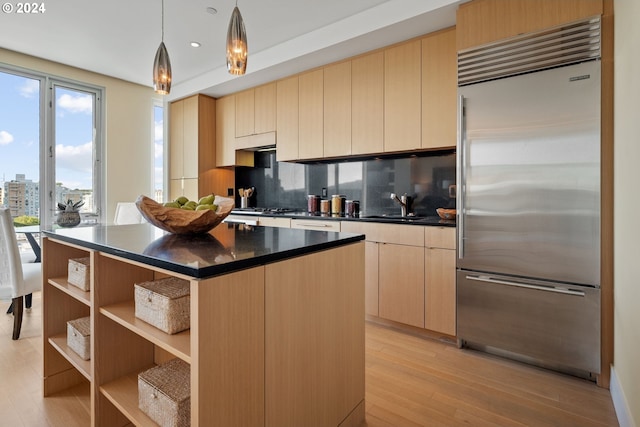 kitchen featuring a kitchen island, sink, hanging light fixtures, light brown cabinets, and stainless steel appliances