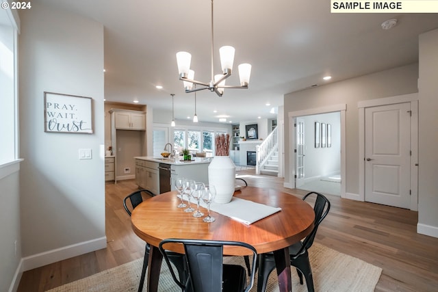 dining area with recessed lighting, a notable chandelier, baseboards, stairs, and light wood-style floors