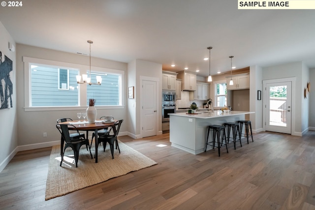 kitchen featuring baseboards, stainless steel appliances, light wood finished floors, and recessed lighting