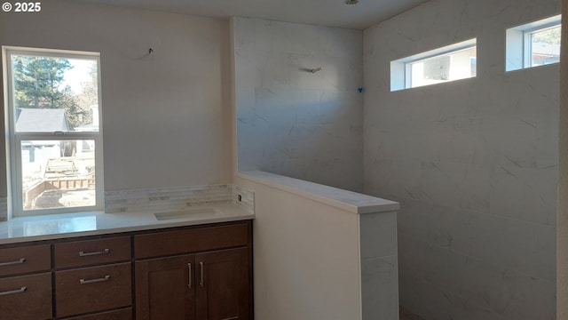 bathroom featuring tiled shower and vanity