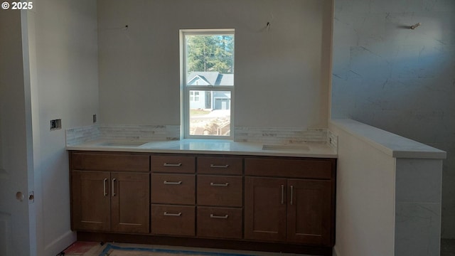 bathroom featuring double vanity, tasteful backsplash, and a sink