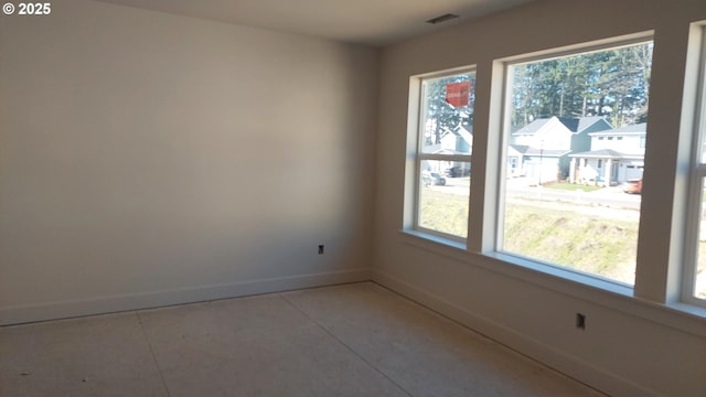 empty room with a healthy amount of sunlight, visible vents, and baseboards