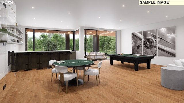 game room featuring light hardwood / wood-style floors, indoor bar, and pool table