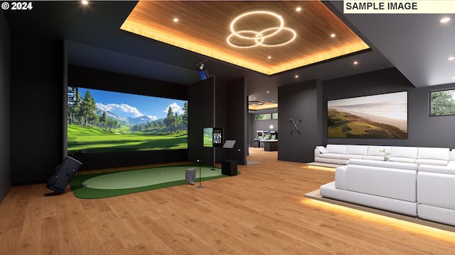 home theater with a tray ceiling, wooden ceiling, golf simulator, and light wood-type flooring