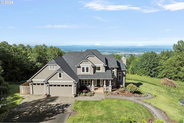 view of front of home featuring a garage, covered porch, and a front lawn