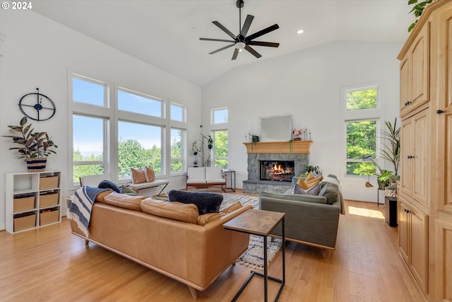 living room with a fireplace, light hardwood / wood-style flooring, high vaulted ceiling, and ceiling fan