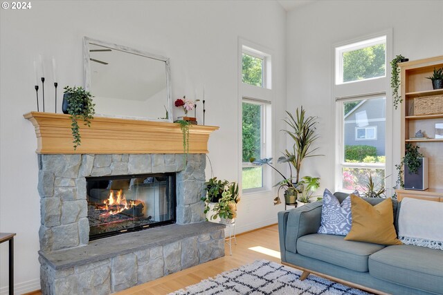 living room with a fireplace, light hardwood / wood-style flooring, and a wealth of natural light