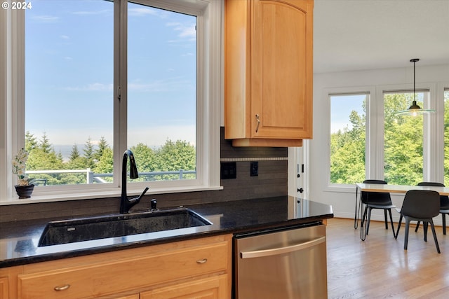 kitchen featuring sink, dishwasher, backsplash, hanging light fixtures, and light brown cabinetry