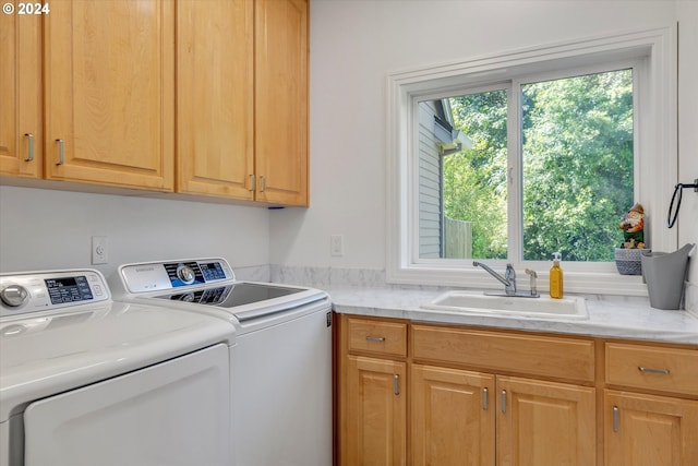 laundry room featuring washer and dryer, sink, and cabinets