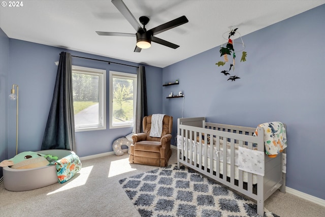 carpeted bedroom with a nursery area and ceiling fan