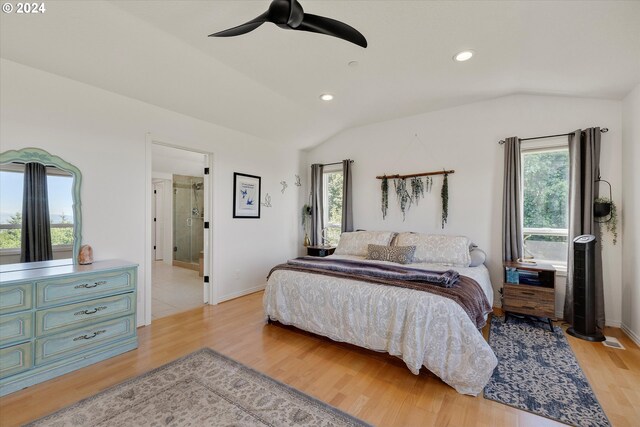 bedroom with light tile patterned flooring, vaulted ceiling, ensuite bathroom, and ceiling fan