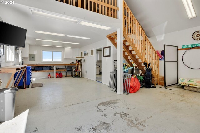 garage with a workshop area and electric panel