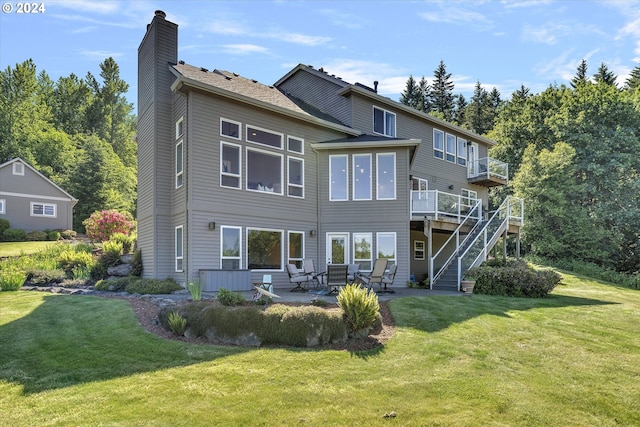 rear view of property with a deck, outdoor lounge area, a patio, and a yard