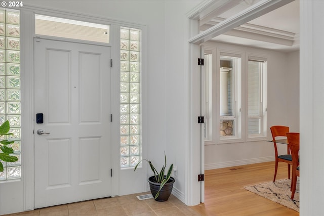 entryway with a tray ceiling and light hardwood / wood-style flooring