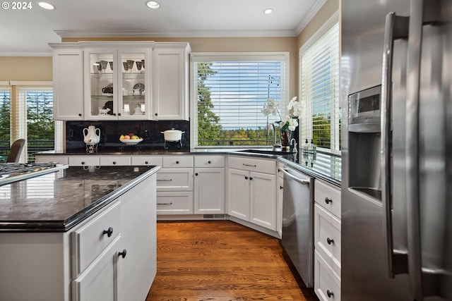 kitchen with sink, ornamental molding, stainless steel appliances, and white cabinets